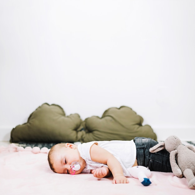 Leuke baby die vreedzaam op kinderdagverblijfvloer slapen