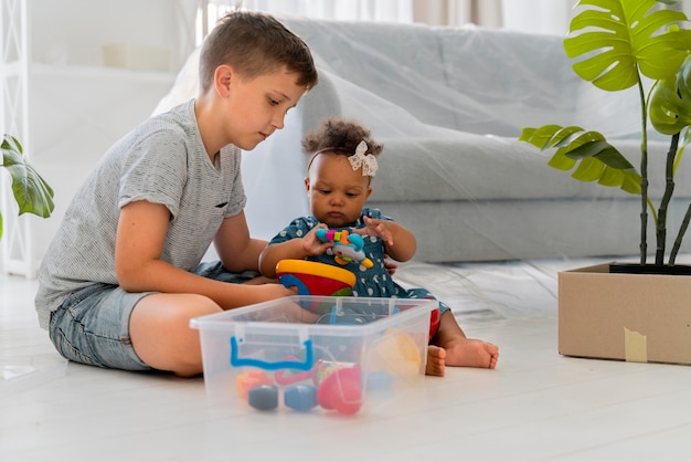 Gratis foto leuke broer of zus die samen speelt voordat ze met hun ouders gaan verhuizen