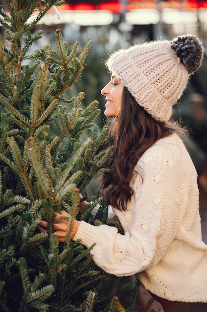 Leuke brunette in een witte trui met kerstboom