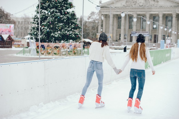 Gratis foto leuke en mooie meisjes in een witte trui in een winterstad