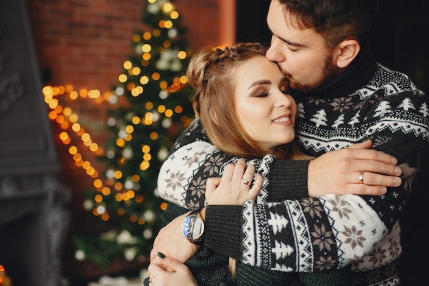 Leuke familie die zich dichtbij Kerstboom bevindt