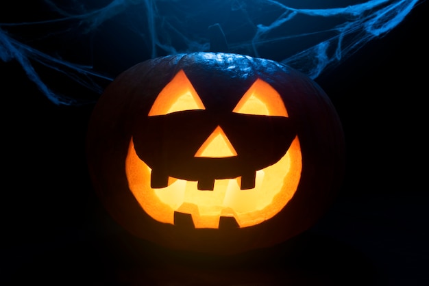 Gratis foto leuke halloween-pompoen en spinnenweb