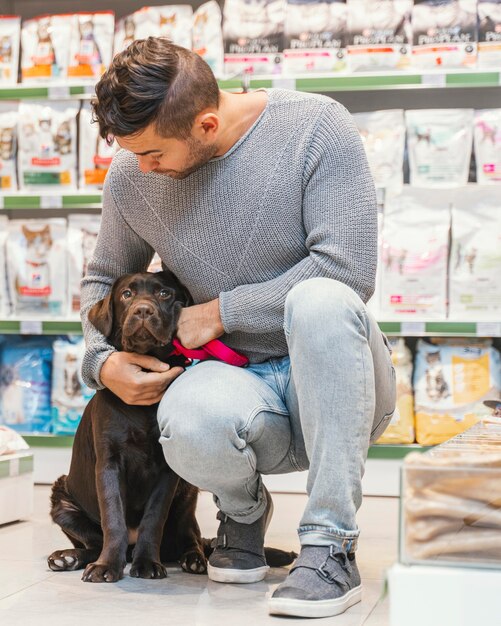 Leuke hond met eigenaar bij de dierenwinkel