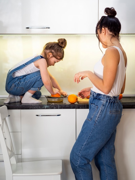 Gratis foto leuke jonge meisje en moeder samen in de keuken