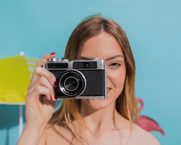 Leuke jonge vrouw die foto op kamer neemt