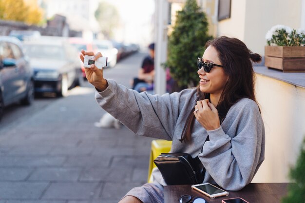 Leuke, jonge vrouwelijke blogger die zich voordeed op camera.