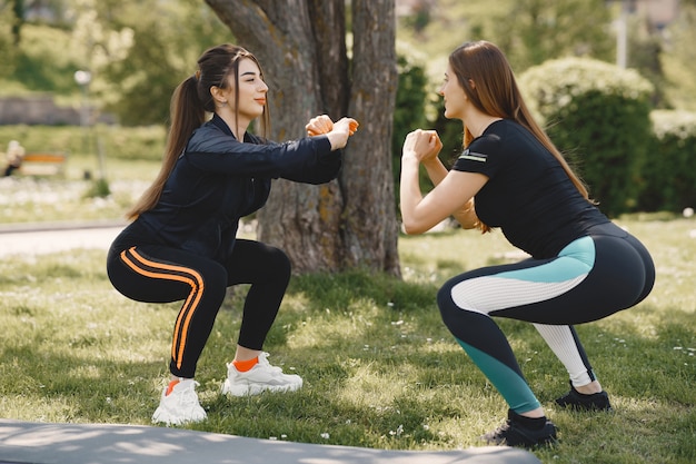 Gratis foto leuke meisjes die yoga in een de zomerpark doen