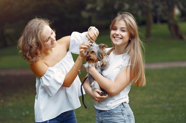 leuke meisjes in een park spelen met kleine hond