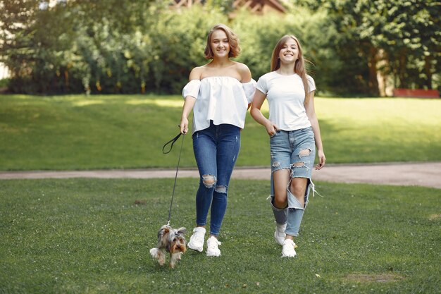 leuke meisjes in een park spelen met kleine hond