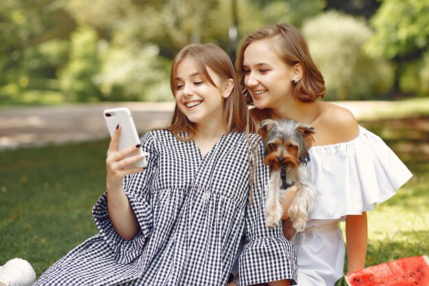 leuke meisjes in een park spelen met kleine hond