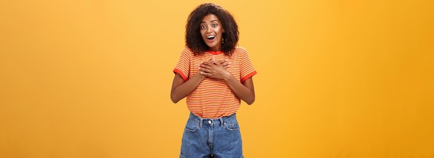 Gratis foto leuke opgetogen afro-amerikaanse vrouw die dankbaar en dankbaar is voor hulp die tevreden over ora staat