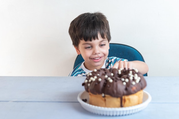 Leuke schattige jongen die in studio chocoladecake eet