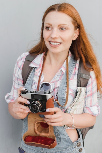 Leuke vrouw met oude camera en rugzak