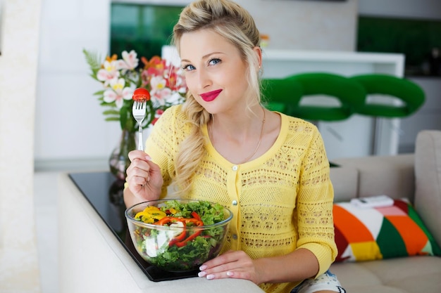 Gratis foto leuke vrouw thuis met salade