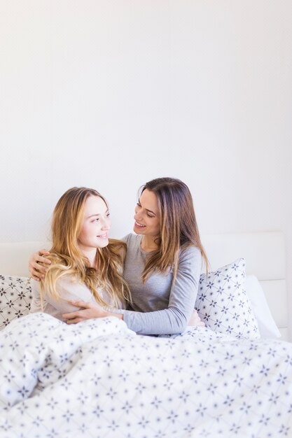 Leuke vrouwen die in bed omhelzen