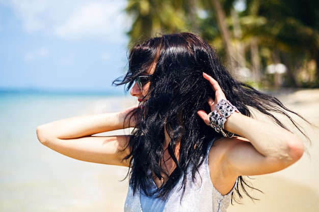 Leuke zomer mode portret van schoonheid brunette vrouw plezier op het strand, dansen en glimlachen