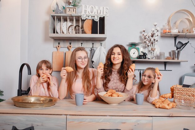 Leuke zusters die zich in een keuken bevinden en broodjes eten