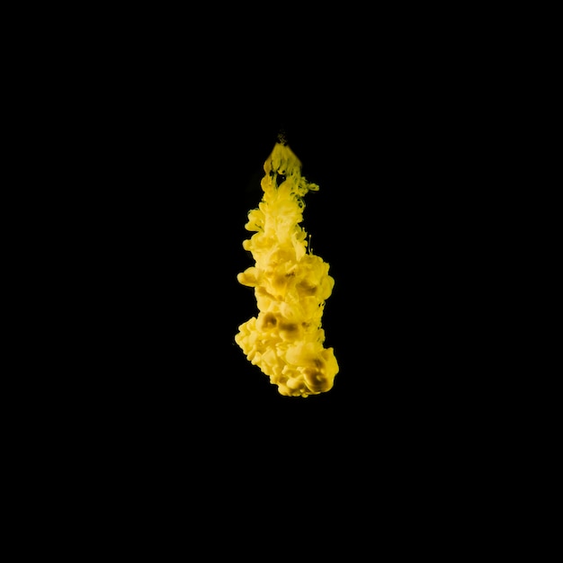 Levendig geel inktdruppeltje in water
