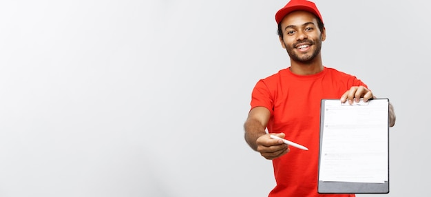 Levering concept portret van knappe Afro-Amerikaanse bezorger of koerier met een bevestigingsdocument formulier om te ondertekenen geïsoleerd op grijze studio achtergrond kopie ruimte