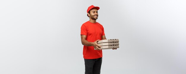 Levering concept portret van knappe Afro-Amerikaanse pizza bezorger geïsoleerd op grijze studio achtergrond kopie ruimte