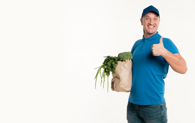 Levering man met boodschappentas en geven duimen omhoog