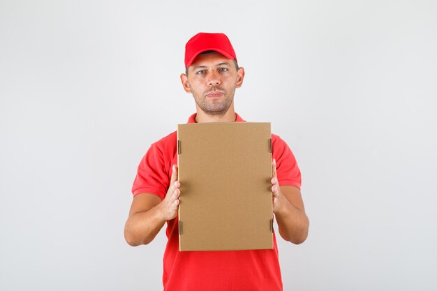 Levering man met kartonnen doos in rood uniform. vooraanzicht.