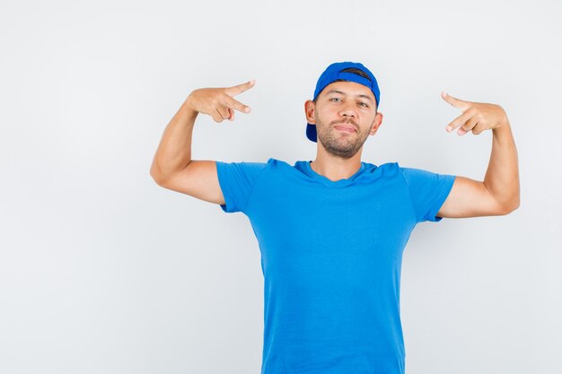 Levering man overwinning teken tonen in blauw t-shirt