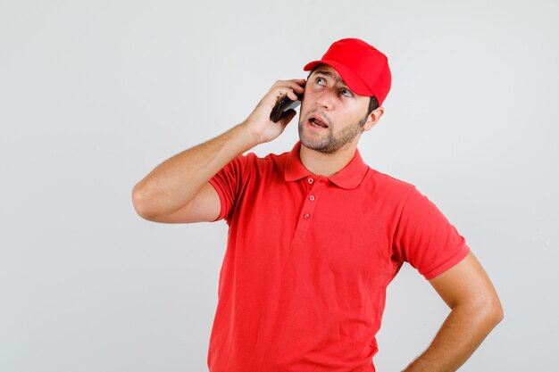 Levering man praten over smartphone in rood t-shirt