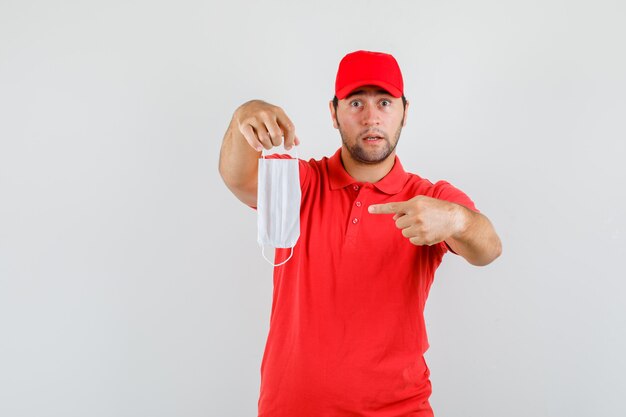 Levering man wijzend op medisch masker in rood t-shirt