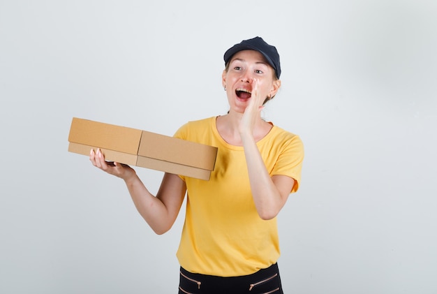 Levering vrouw met kartonnen doos en schreeuwen in t-shirt, broek en pet