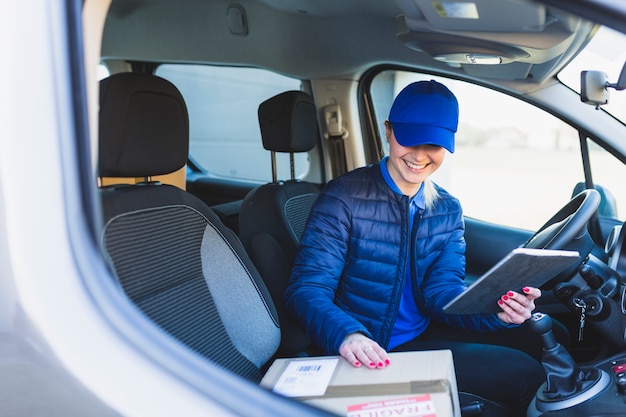 Gratis foto leveringsmeisje met tablet in auto