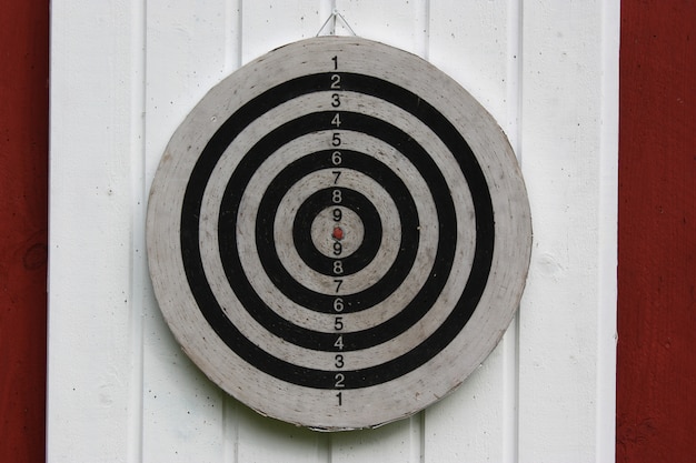 Gratis foto lichte close-up shot van een dartbord gehangen op een witte en rode muur