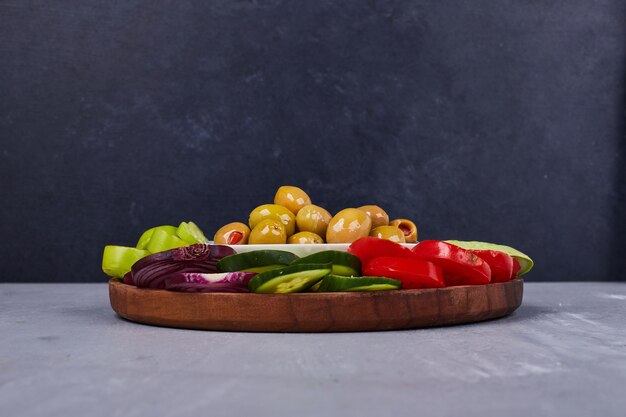 Lichte salade met groenten en kruiden in een houten schotel.