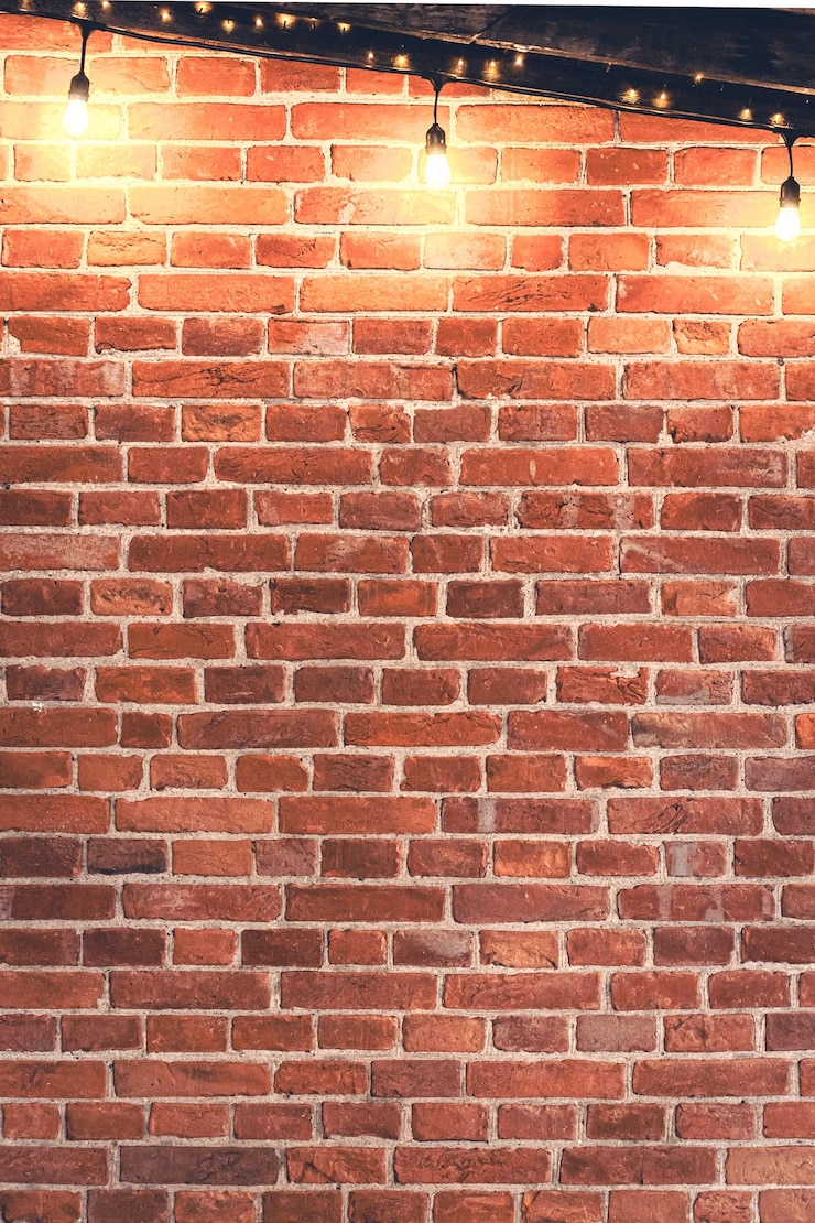 Gratis Foto lichten kralen die's avonds aan een rode bakstenen muur hangen.
