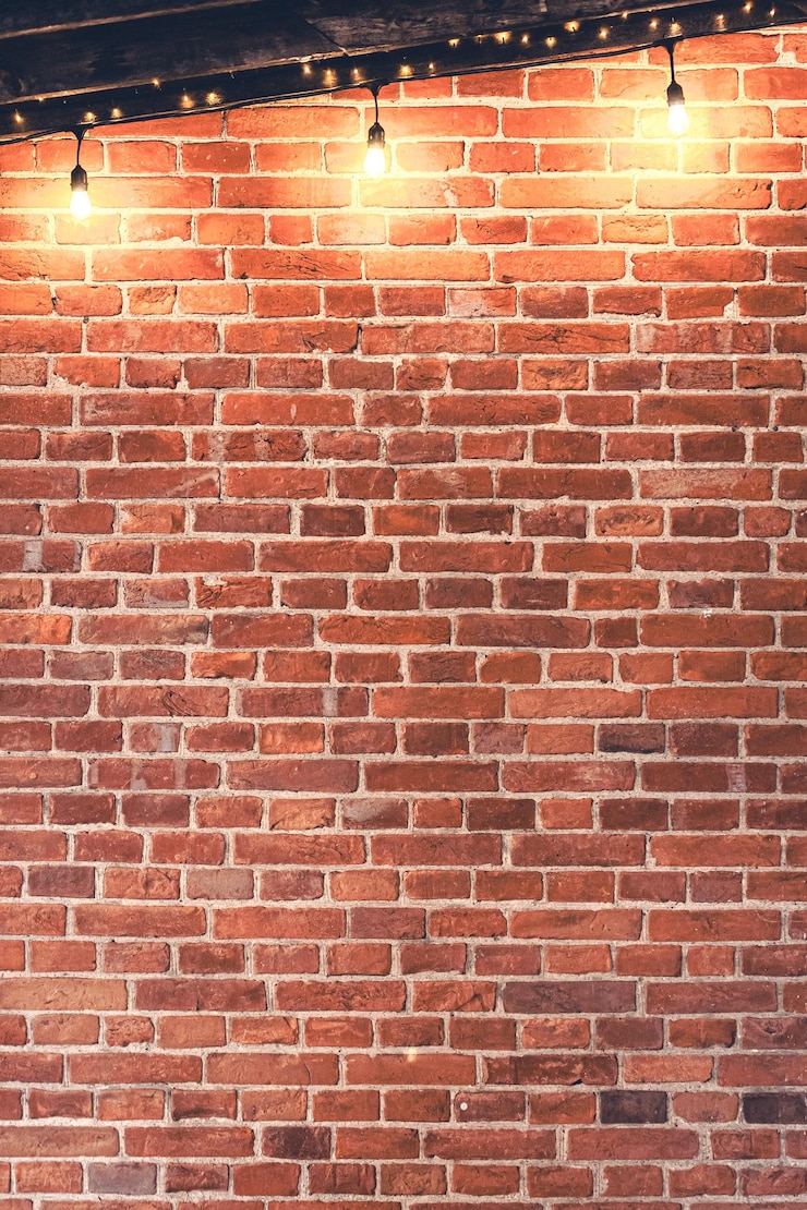 Gratis Foto lichtslingers hangen 's avonds aan de rode bakstenen muur