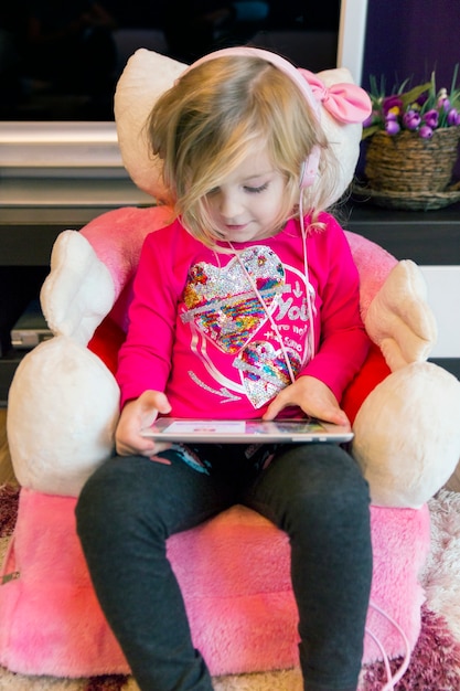 Gratis foto lief meisje in hoofdtelefoons browsen tablet