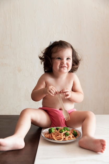 Lief meisje speelt met spaghetti