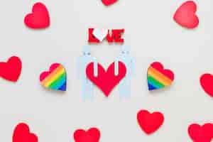 Gratis foto liefde inscriptie met regenboog harten en homo paar pictogram