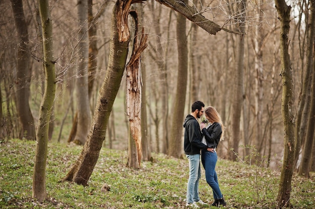 Gratis foto liefdesverhaal van cool multiraciaal stel in het lentebos