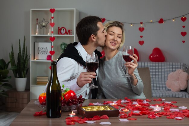 Liefdevolle gelukkige jonge paar zittend aan tafel Valentijnsdag thuis vieren