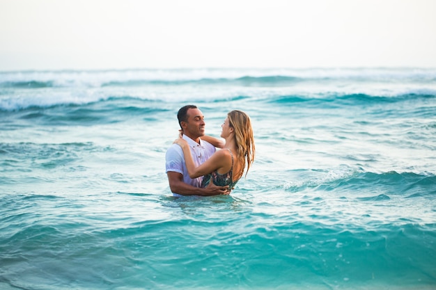 Liefdevolle paar staande in water en knuffelen