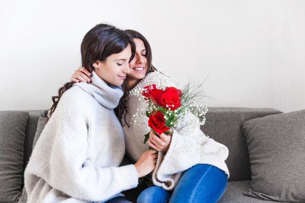 Liefhebbende vrouwen met rozen op de sofa