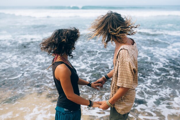 Liefhebbers hand in hand en kijken naar de zee