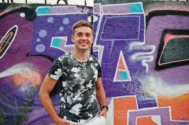 Lifestyle portret van knappe man die zich voordeed op de straat van de stad met graffiti muur