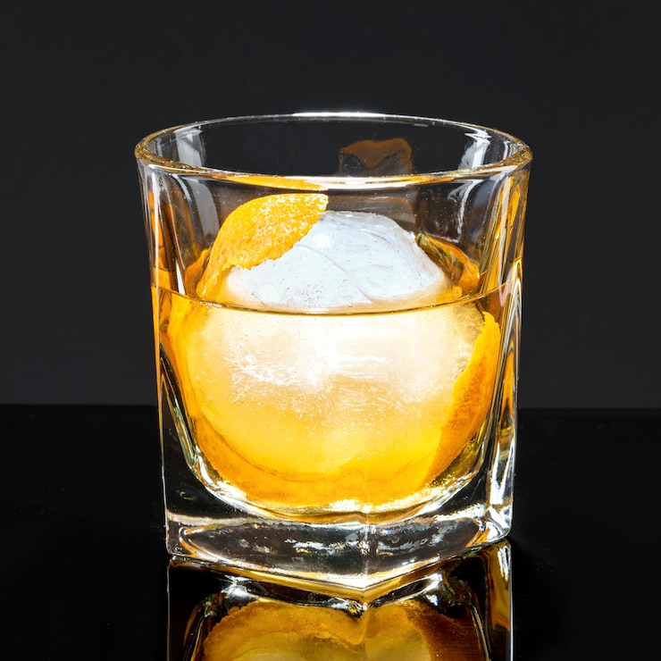 Gratis Foto likeur met een sinaasappelschilcocktail