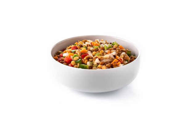 Linzensalade met peppersonion en wortel in een kom die op witte achtergrond wordt geïsoleerd