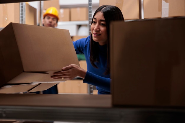 Logistiek manager doet kwaliteitscontrole van goederenpakketten tijdens het doorzoeken van kartonnen dozen op de plank. E-commerce retail magazijnmedewerker die pakket vasthoudt om klantorder in te pakken voor verzending