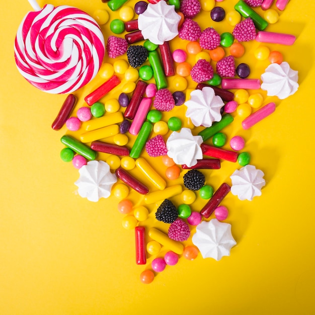 Lollipop en snoepjes op gele achtergrond