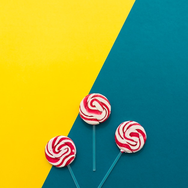 Gratis foto lollipops op gele en blauwe achtergrond