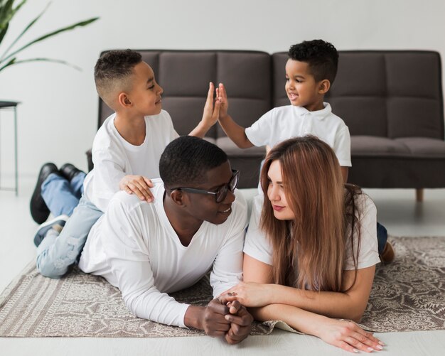 Long shot familie ontspannen op de vloer samen